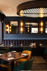 A dimly lit dining room with booth seating running the length of the wall.
