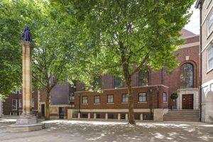 Quiet Church Court at Inner Temple featuring mature leafy trees, red brick buildings, and a central paved courtyard.
